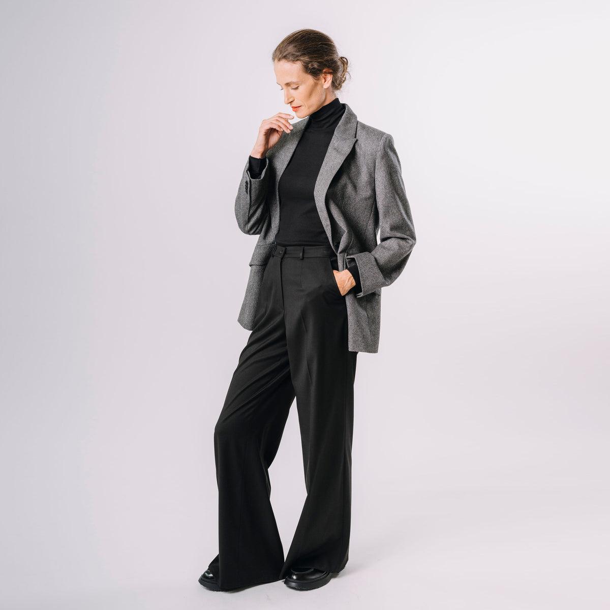 Grauer Blazer mit schwarzem Rollkragen und weiter Hose