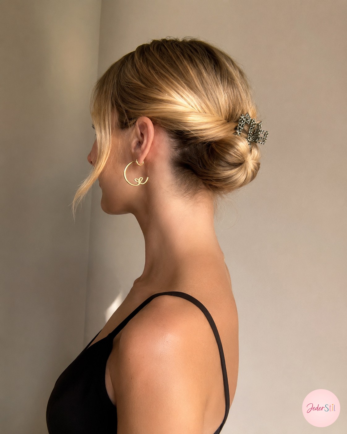 Ein tief getwisteter Dutt mit Schmuckclip zeigt eine elegante Frisur für feines Haar am Abend