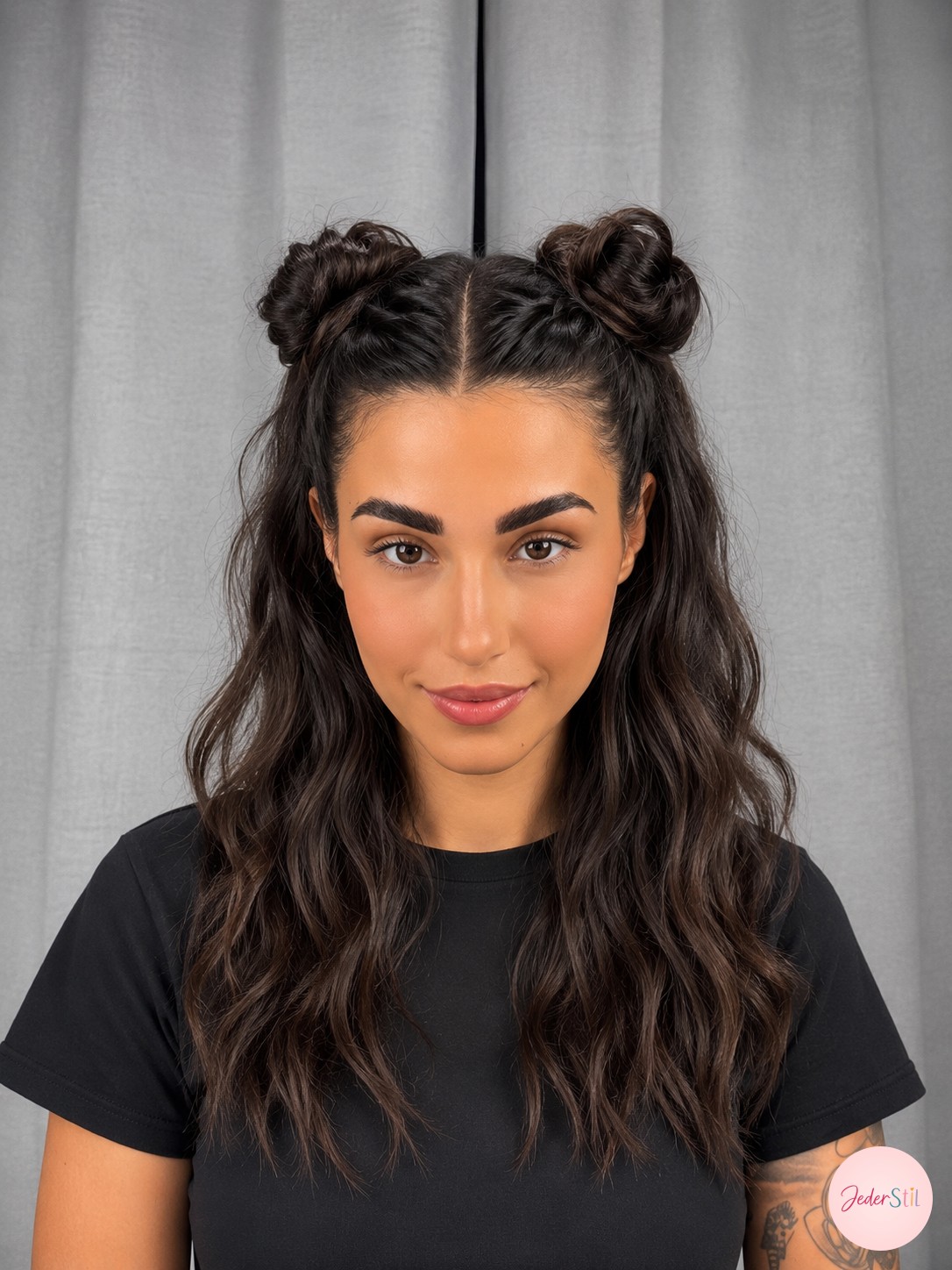 Frau mit zwei Space Buns und offenen Wellen auf mittellangem braunen Haar