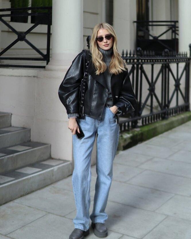 Schwarze Lederjacke mit grauem Oberteil und blauer Jeans