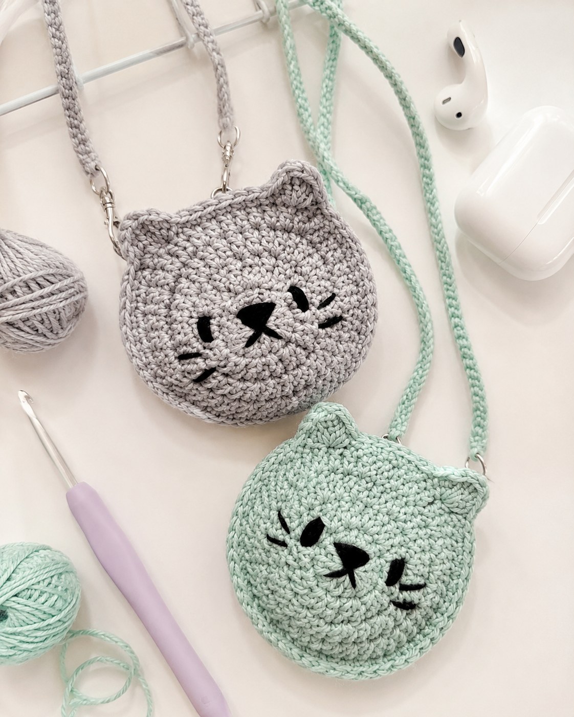 Zwei Katzengesicht-Täschchen in Grau und Mint zeigen eine funktionale Variante beim Mini Katzen häkeln