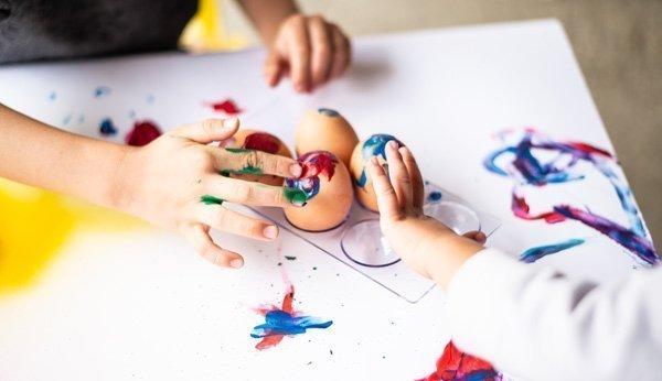 Kinder bemalen Ostereier Fingerfarben