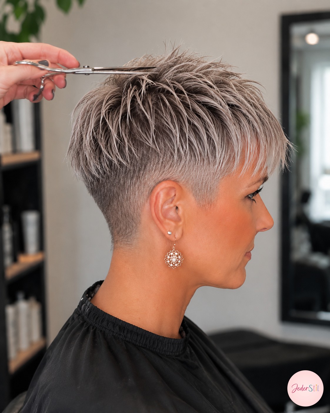 Rundbürste und Fön heben die Wurzeln für Volumen im fertigen Pixie Cut graue Haare.