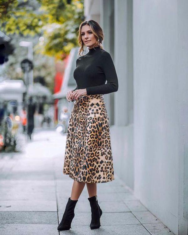 Schwarzer Rollkragenpullover mit gemustertem Midirock und Boots